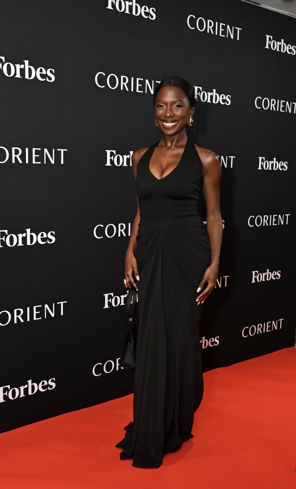 Toni Bravo in a black Rhea Costa gown on the Forbes and Corient red carpet