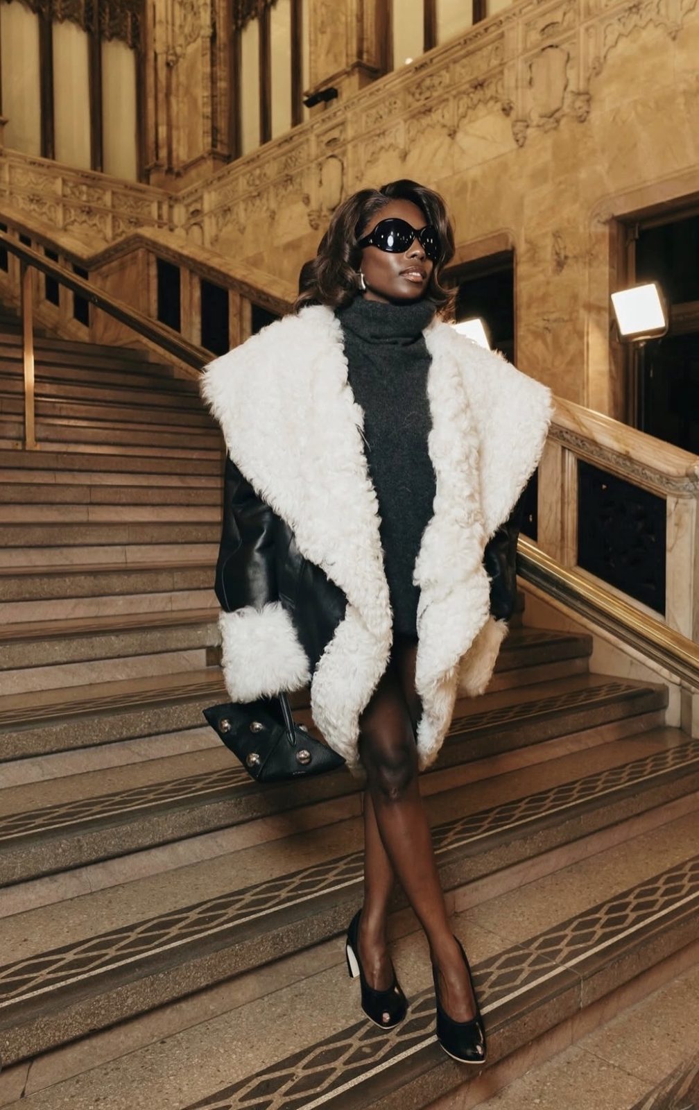 Toni Bravo on a marble staircase in an Altuzarra shearling-trimmed leather coat